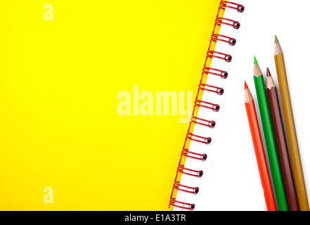 Vier bunte Bleistifte auf weißen Lehrbuch mit allerlei textfreiraum Text hinzufügen Stockfoto