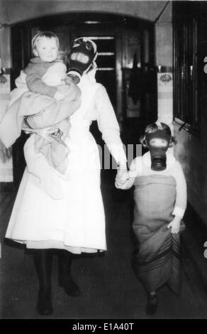 BRITISH HOME FRONT WW2 A Krankenschwester führt ein Kind und Baby in Armen ins Tierheim bei einem mock Gasangriff. Stockfoto