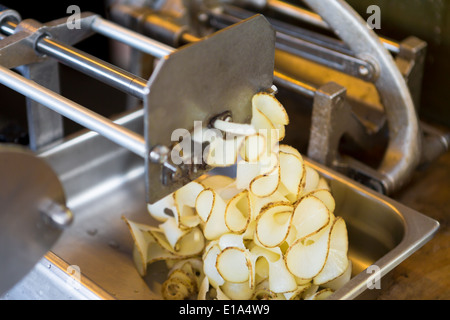 Lockig, Kartoffel Pommes frites Schleifenmaschine in Aktion Prepearing Kartoffeln für Friteuse Stockfoto