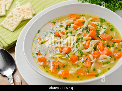 Herzhafte hausgemachte Huhn-Nudelsuppe mit Soda Crackern. Stockfoto