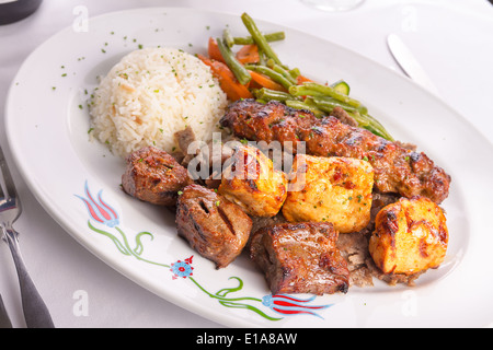 Hühner gemischt, serviert Lamm Adana Shish Kebab serviert auf Gyros Döner mit Reis servieren und garniert mit grünem Gemüse, Stockfoto