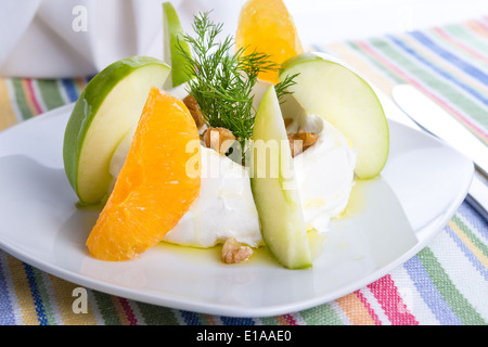 Gespannte Joghurt Labneh Zitrus-Salat mit geschälte Orangen und grünen Äpfeln garniert mit Dill und Walnüssen serviert mit Öl Stockfoto