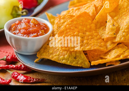 Ein Teller mit pikanter Käse-Nacho-Chips mit Salsa. Stockfoto