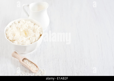 Reisbrei mit Butter und Sahne in kleinen Krug. Selektiven Fokus. High-Key. Kopieren Sie Weltraum Hintergrund. Stockfoto