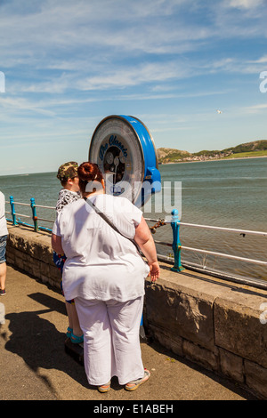 Über Gewicht Frau, stehend auf Outdoor-Skalen auf Llandudno Pier mit einem Freund, Llandudno, Wales, Vereinigtes Königreich. Stockfoto