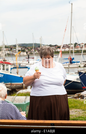 Übergewicht mit einer Eistüte in der Hand Conway, Frau, Wales, Großbritannien. Stockfoto