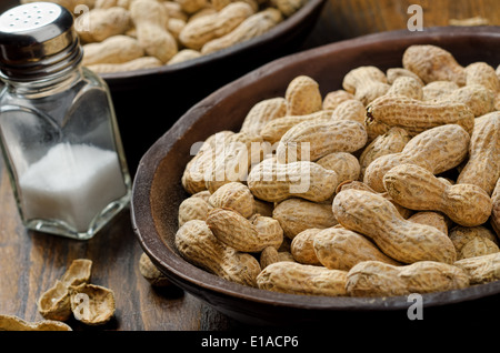 Eine Schüssel mit ganze Erdnüsse in der Schale mit Kochsalz. Stockfoto