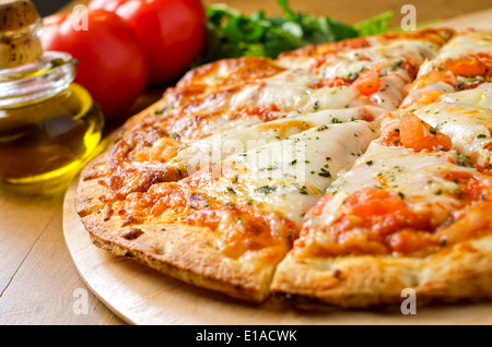 Eine frisch gebackene Pizza Margherita mit Tomaten, Olivenöl, frischem Basilikum und Mozzarella-Käse. Stockfoto