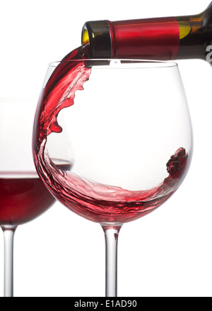 Ein Glas Rotwein aus der Flasche gegossen wird. Stockfoto