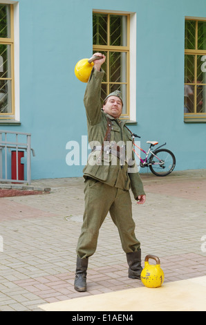 Mann in uniform Training mit Kettlebell. Leistung für die Gäste des Museums. Stockfoto