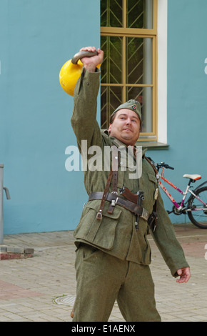 Mann in uniform Training mit Kettlebell. Leistung für die Gäste des Museums. Stockfoto