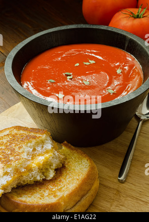 Eine herzhafte Schüssel hausgemachte Tomatensuppe und ein Käse-Sandwich. Stockfoto