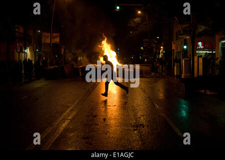 Barcelona, Spanien, 28. Mai 2014. Ein Mann läuft vor einem brennenden Barrikade in den Straßen von Barcelona.  Zweite Nacht der Proteste und Unruhen im Stadtteil Sants Barcelona nach der Räumung von einem besetzten Haus von der Polizei. Bildnachweis: Jordi Boixareu/Alamy Live-Nachrichten Stockfoto