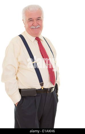 Geniale senior Geschäftsmann in geschweiften Klammern stehen in einer sicher entspannte Pose mit seinen Händen in der Hosentasche lächelnd mit Strapsen Stockfoto