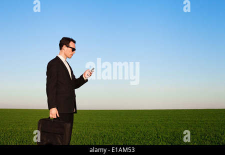 Geschäftsmann mit Smartphone im grünen Bereich Stockfoto