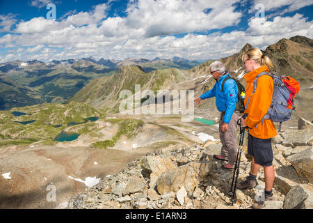 Zwei Wanderer auf der Fuorcia da Barcli übergeben, mit Blick auf das Seenplateau Seen, Nationalpark, Graubünden, Schweiz Stockfoto