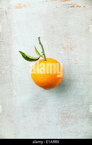 Reife Orange mit Blatt auf strukturierten Hintergrund Stockfoto