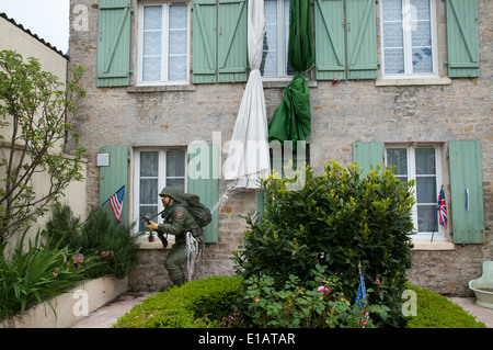 Modell der amerikanischen Fallschirmjäger vor Garten des Hauses in Sainte Mer Eglise Stockfoto