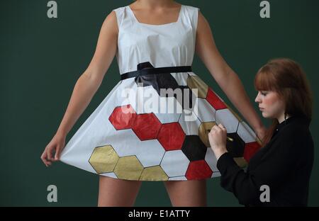 Magdeburg, Deutschland. 28. Mai 2014. Angehende Modedesigner Leonie Maziossek Farben eine Kleid, das anlässlich der bevorstehenden Fußball-WM in der "Schule Für Mode Und Design" entwickelt wurde (wörtl. Schule für Mode und Design) in Magdeburg, Deutschland, 28. Mai 2014. Junge Mode-Designer eine Kollektion für weibliche Fußballfans aus recycelbare Material erstellt. Die Stücke können mit Fußball-Muster und Nationalfarben mit Marker und Lackstifte bemalt werden. Foto: JENS WOLF/Dpa/Alamy Live News Stockfoto