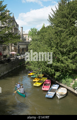England, Oxford. Ein Mann und eine Frau Kanu Vergangenheit vertäut Ruderboote am Fluss Cherwell, Oxford, UK Stockfoto