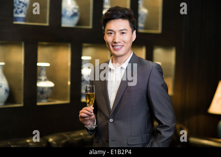 Junger Geschäftsmann mit Champagner Stockfoto