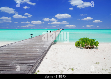 Holzsteg auf über den schönen Malediven Strand mit blauem Himmel und Wolken Stockfoto