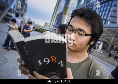 Bangkok, Bangkok, Thailand. 29. Mai 2014. Ein Mann liest während einer Proteste gegen den Thai Putsch Donnerstag '' 1984''. Etwa acht Menschen versammelten sich an der Kreuzung Chong Nonsi in Bangkok um lautlos lesen Orwells "1984" und andere Bücher über zivilen Ungehorsam. Die Proteste basieren auf der '' Mann stehend '' Proteste, die letzten Sommer in der Türkei begonnen. Die Behörden gaben sich keine Mühe, den Protest zu stoppen oder stören die Menschen, die lasen. Bildnachweis: Jack Kurtz/ZUMAPRESS.com/Alamy Live-Nachrichten Stockfoto