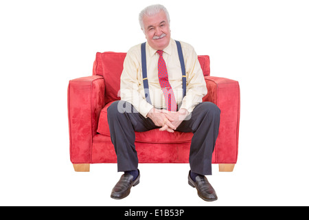 Studio-Porträt über weiß von einem senior weißen Haaren Mann in einem bequemen roten Sessel entspannen. Stockfoto