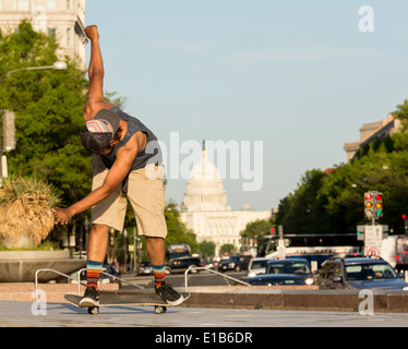 Skateboarder Abschluss Sprung Stufen auf Freiheit Plaza an der Pennsylvania Avenue vor der Kuppel des Kapitols des Kongresses auf anstrengenden Nachmittag in Washington DC USA mit Teleobjektiv Komprimieren der Szene Stockfoto