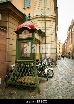 Eine alte traditionelle Telefonzelle (Rikstelefon Marke Kriegsministerium, jetzt Telia) in der Altstadt Gamla Stan, Stockholm, Schweden. Stockfoto