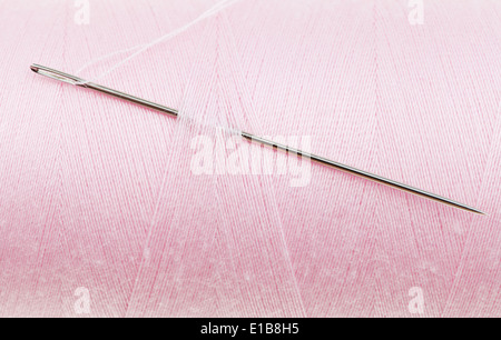 Hand-Nähnadel in rosa Faden Spule hautnah Stockfoto