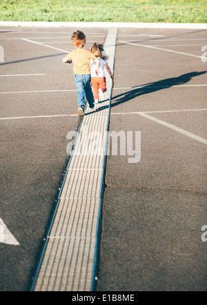 Bruder hilft Schwester auf der Straße weglaufen Stockfoto