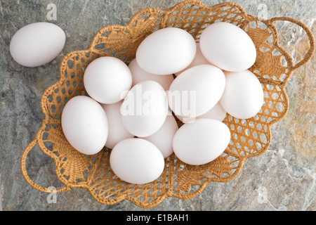 Obenliegende Detailansicht einen dekorativen geflochtenen Weidenkorb Ostern mit traditionellen frische weiße Ostereier gefüllt Stockfoto