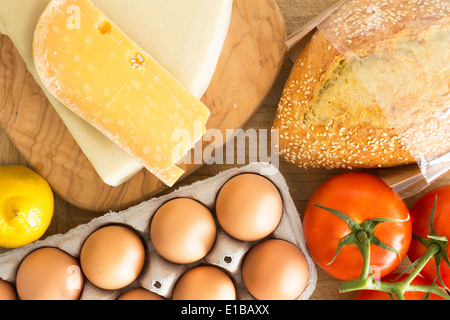 Draufsicht auf frische Lebensmittel in der Küche mit einem Karton Karton Freilandhaltung Eiern, Traube Tomaten am Rebstock, Käse, Stockfoto