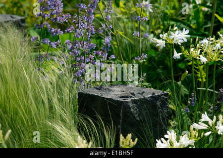 Blumen rund um den Granit zu blockieren, in der Hoffnung auf die Horizont-Hilfe für Helden-Garten bei der Chelsea Flower Show 2014 London UK Stockfoto