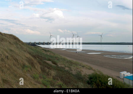 20. Mai 2014 - Zeeland, Niederlande - der Brouwersdam, ein Teil der Deltawerke in den Niederlanden. Vorne gehen die Menschen am Strand. Die Deltawerke sind die besten und größten Sturm Barrieren in der Welt. Es gibt einen Grund, warum die Dämme "das achte Wunder der Welt" genannt werden. Sie wurden nach den Überschwemmungen von 1953 und bieten Schutz für das Land rund um die Rhein-Meuse-Schelde-Delta entwickelt. Mit den Deltawerken haben die Chancen auf eine weitere Flut auf einmal in 4000 Jahren reduziert. Die Arbeiten bestehen aus Dämme, Schleusen, Schleusen, Deiche, Dämme und Storm Surge Barrieren. Das Ziel der Stockfoto