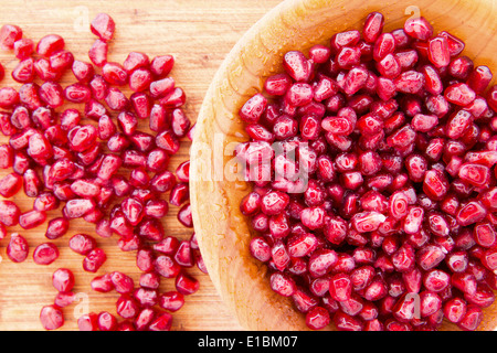 Holzschale mit gefüllt, gereinigt und vorbereitet, saftige Reife Granatapfelkerne oder Arils reich an vItamin K und Antioxidantien Stockfoto