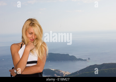 schöne junge blonde Frau vor der Insel Stockfoto