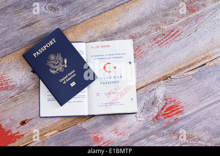 Einen amerikanischen und türkischen Pass auf einem alten Holztisch liegend mit den türkischen Pass geöffnet, um einen abgebrochenen Handstempel anzuzeigen Stockfoto