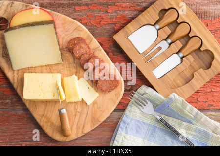 Draufsicht auf eine Käseplatte mit verschiedene Käsesorten Havarti, Manchego und Gouda einschließlich serviert mit in Scheiben geschnittenen Chorizo auf eine Stockfoto