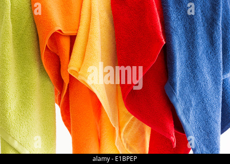 Bunte lebendige Frische sauberen weichen Handtücher hängen in einer Reihe in den Farben des Regenbogens auf weißem Hintergrund Stockfoto