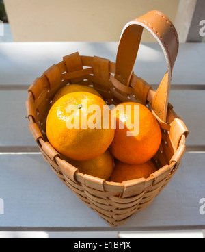 Orangen in den Korb auf weißen Stuhl. Stockfoto
