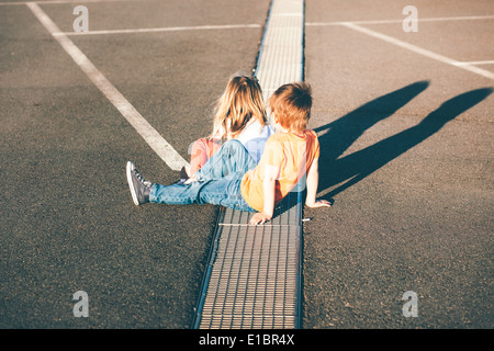 Bruder hilft Schwester auf der Straße weglaufen Stockfoto