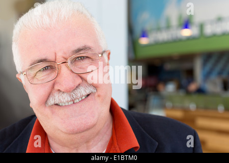 Porträt des Gesichts eine attraktive freundlich aufrichtige ältere grauhaarige Mann in Gläsern mit einem Schnurrbart auf der Suche schließen Stockfoto