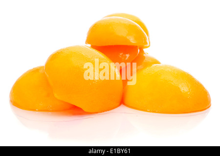 einige geschälte und halbierte Pfirsiche in Sirup auf weißem Hintergrund Stockfoto