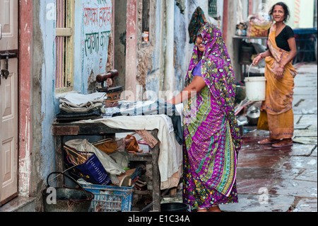 Unbekannte Frau Wäsche bügelt mit alten Kohle Eisen auf der Straße am 23. Oktober 2011 in Ajmer, Rajasthan, Indien. Stockfoto