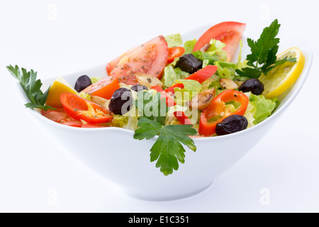 Frischer mediterraner Salat mit schwarzen Oliven, Tomaten, Petersilie, Zitrone, Paprika, Salat, gewürzt mit Olivenöl, Zitrone, oregano Stockfoto