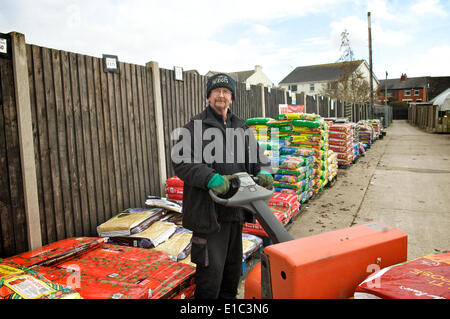 Mann stapelt Torf im Gartencenter Stockfoto