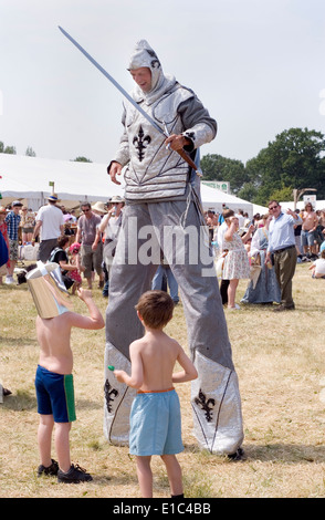 Tewkesbury Mittelalterfest, Gloucester UK Juli 2013: Ritter auf Stelzen unterhält zwei jungen Stockfoto