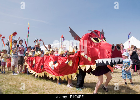 Tewkesbury Mittelalterfest, Gloucester UK Juli 2013: Alchemie unterhalten Kinder mit riesigen Marionetten Drachen an die Drachenparade Stockfoto